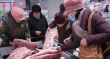 Consumidores selecionam carne de porco congelada em Nantong, China